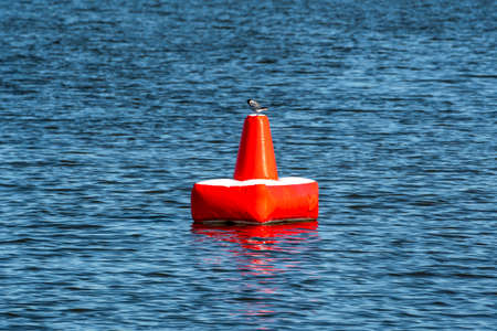 Red inflatable buoy on the blue sea. A buoy is a floating device that can have many purposes.の写真素材