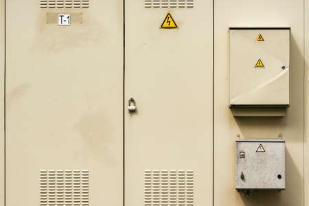 Electrical cabinet with warning signs and padlocks at a streetの写真素材
