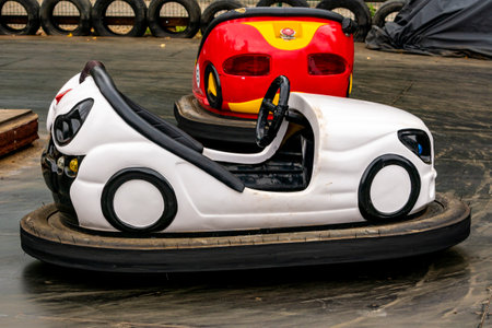 White and red bumper cars at the amusement park. Fairground with attractions. Colorful dodgems.の写真素材