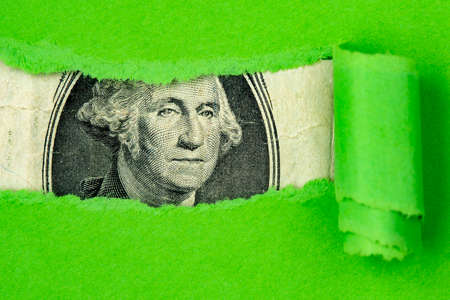US currency macro peeking through torn green paperの写真素材