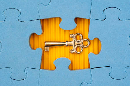 Find key to success, business opportunity or solution. Blue jigsaw puzzle with small key.の写真素材