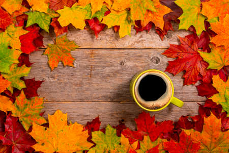 Hot coffee cup and autumn leaves on wood background - relax or retirement conceptの写真素材