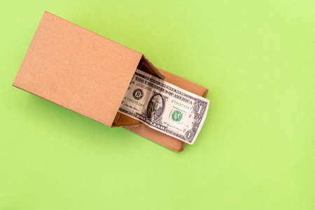 A dollar bulging out of a cardboard box. Financial concept.の写真素材
