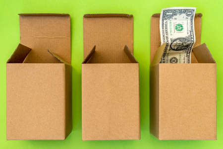 Three open boxes and dollar bulging out of one of them. Financial concept.の写真素材