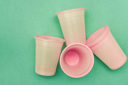 Empty disposable pink plastic cups on the blue backgroundの写真素材