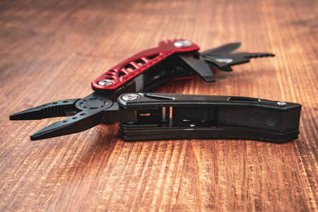 Steel multi tool on the wooden background. Selective focus, shallow DOF.