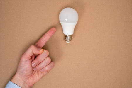 Creative idea.Concept of idea and innovation.Hand finger pointing to light bulb on cardboard...