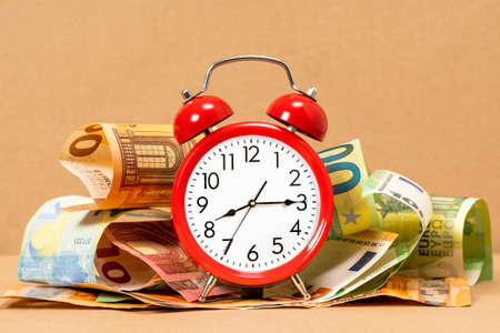 Retro style alarm clock and Euro currency. Time is money conceptの写真素材