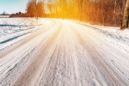Snowy Forest Road  on a Sunny Winter Morning. Concept of Dangerous Driving Conditions.の写真素材