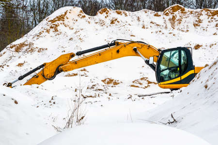 Excavator machine working at sand quarry during winter time. Construction industry.の写真素材