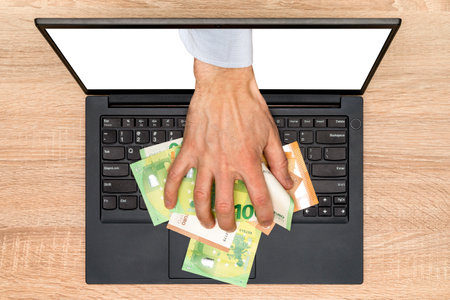 Hand reaching out of laptop screen to steal money. Stealing a money through a laptop, concept for...