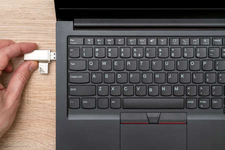 Plugging removable flash disk memory into laptop USB slot. The concept of data storage