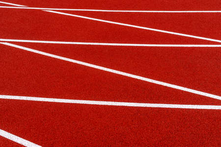Red running track field at stadium with white linesの写真素材
