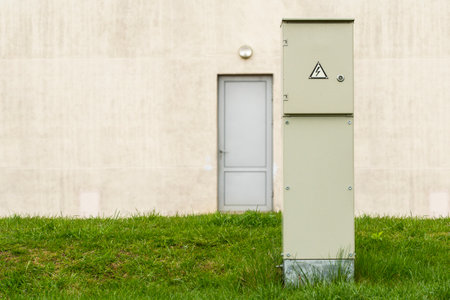 Outdoor electric high voltage cabinet in a front of the building wallの写真素材