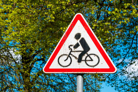 Transport warning symbol in a red triangle. Bicycle traffic sign close-up.Cycle route ahead.