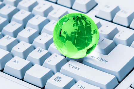 Green crystal globe of the Earth on a computer keyboard. Global & international business concept. World connected. Social network concept.の写真素材