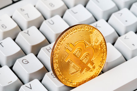 Bitcoin cryptocurrency. Gold bitcoin and computer keyboard. Golden digital cryptocurrency coin. Electronics finance money symbol. Selective focus.の写真素材