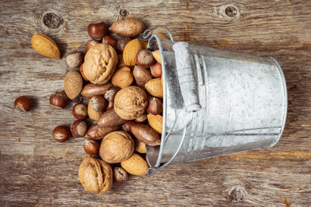 Tiny bucket of assorted nuts on a wooden background. Nuts are a healthy and nutritious food.