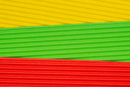 Striped colorful embossed paper. Colored paper background. Yellow,green and red.の写真素材