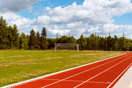 Empty school stadium with football gate and running track. Concept of training in football sections...