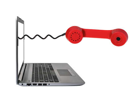 Red phone receiver coming out of a laptop screen. Customer service concept.の写真素材