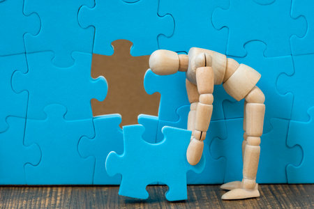 Dummy assembling last missing puzzle on puzzle wall. Creating or building own business concept.