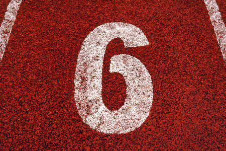 The number 6 at start point of running track or athlete track in stadium. Running track is a rubberized artificial running surface for track and field athletics.の写真素材