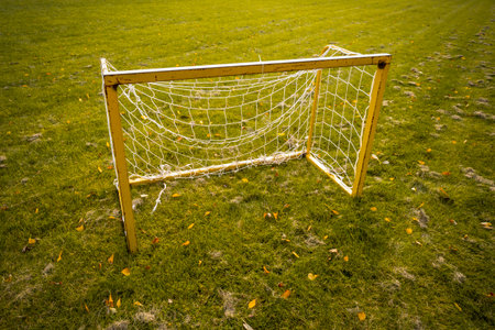 Small yellow football goals on a stadium field during autumn season. Football goals for kids training.の写真素材
