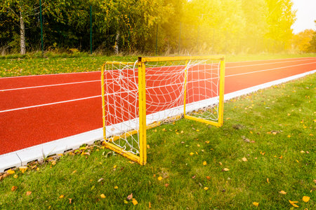 Small football goals next a running track in a stadium during autumn season. Football goals for kids training.の写真素材