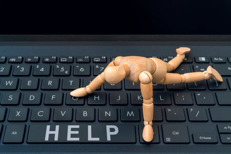 Online HELP button. Wooden dummy trying to reach HELP button on a computer keyboard.