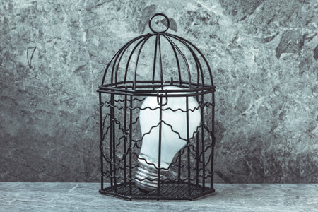 A light bulb in a cage.Blocking new ideas concept.の写真素材