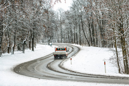 Mini truck passing on a highway with snow slush and snow fall, winter sceneryの写真素材