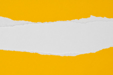 Yellow paper with torn edges on white paper background inside. Paper texture, copy space.の写真素材