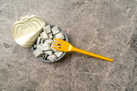 Hungry for information: yellow fork and tin can full of computer keyboard keys