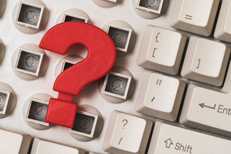 Close-up of a disassembled computer keyboard with a red question mark on it. Conceptual image.