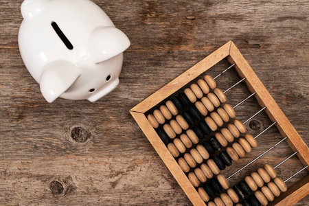 Piggy bank and vintage abacus and on wooden background. Top view.の写真素材