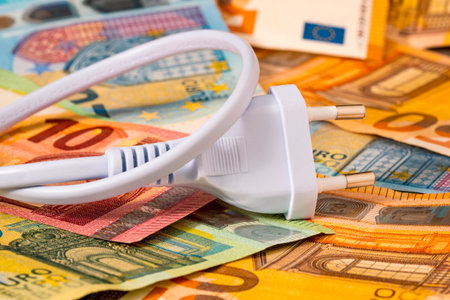 White electric plug on a pile of euro currency. Payment of electricity bills. Rise in electricity prices concept.の写真素材