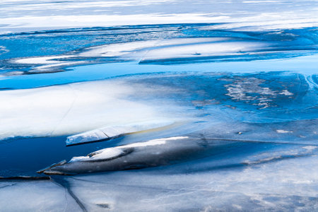 Broken ice lake. Ice background, frozen lake or river covered by ice. Spring is coming.の写真素材