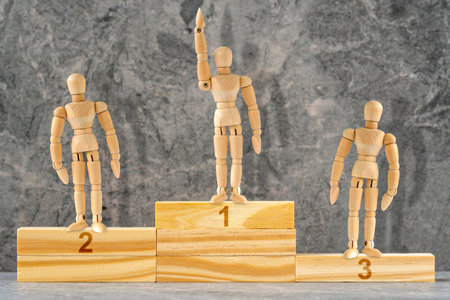 Wooden mannequins standing on the podium rank first three places.  Employee recognition and competition award winner business concept. Pedestal or platform for honoring prize winners.の写真素材