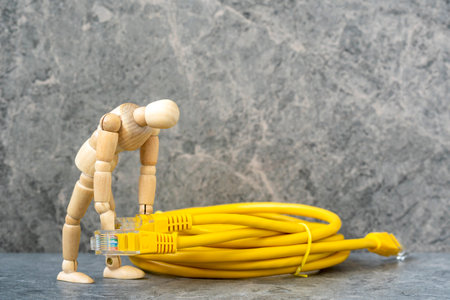 Wooden man holding LAN network connection cables. Concept of network troubleshoot supporter or...