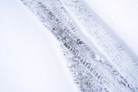 Trace of car tire in the fresh snow. Close up view from above.の写真素材