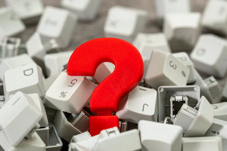 Red plastic question mark in the pile of computer keyboard keys. Business customer service and support online concept.の写真素材