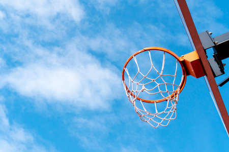 Basketball hoop against a blue sky from a low angle.Low angle shot of basketball hoop on sunny day...