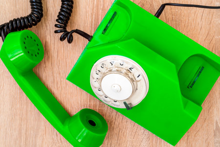 Old green telephone on wooden table, top view. Vintage phone with taken off receiver.の写真素材