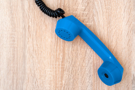 Vintage telephone handset. Old blue telephone receiver on the wooden background. Copy space.の写真素材