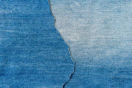 Denim blue jeans fabric background. Ripped denim fabric. Destroyed torn denim blue jeans texture.の写真素材