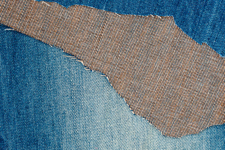 Denim blue jeans texture with copy-space for text. Ripped denim fabric. Destroyed torn denim blue...