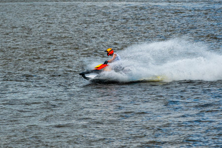 Unrecognizible Jet ski driver in action during show with splashing water