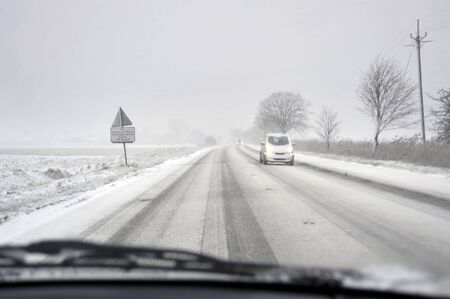Winter road driving in the countryside with falling snow, UK.の写真素材
