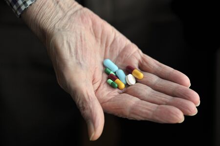 Old age pensioner holding daily medications.の写真素材